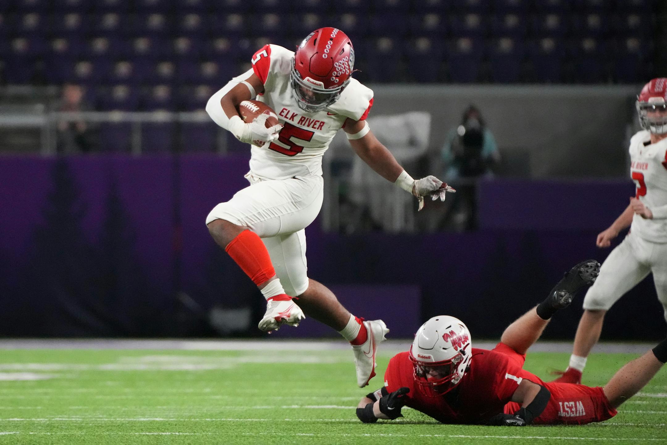 Elk River's Myles Gordon (5) evades the tackle of Mankato West Damian Riewe (1) in the second half of the Minnesota High School football Class 5A State Championship at U.S. Bank Stadium in Minneapolis, Minn., on Saturday, Dec. 3, 2022.