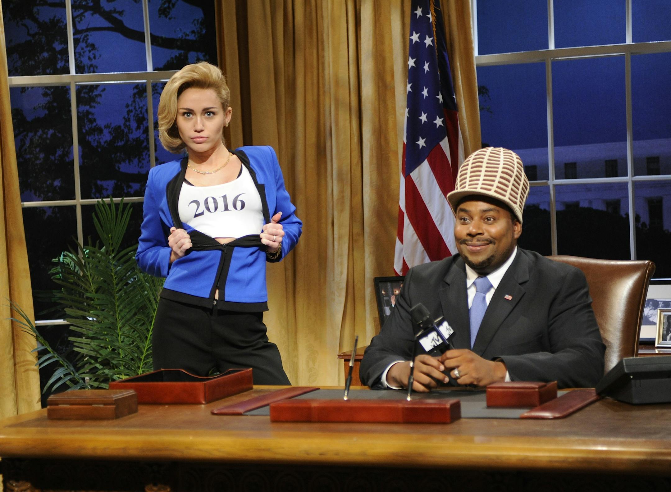 This Oct. 5, 2013 photo released by NBC shows guest host Miley Cyrus, left, and Kenan Thompson in a scene from the late-night comedy series "Saturday Night Live," in New York. (AP Photo/NBC, Dana Edelson)