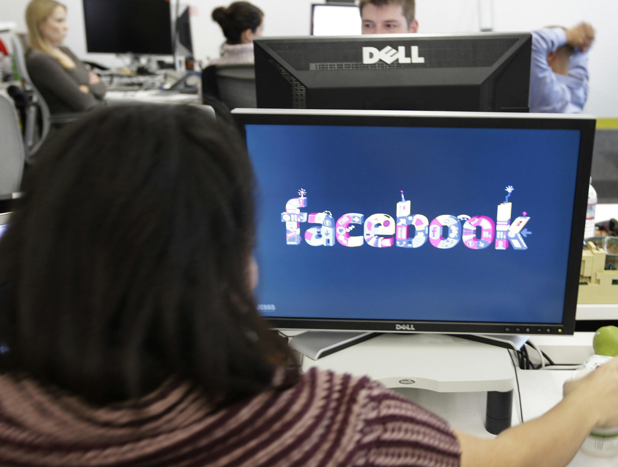 FILE -This Dec. 13, 2011 file photo, shows workers inside Facebook headquarters in Menlo Park, Calif. Facebook, the social network that changed "friend" from a noun to a verb, is expected to file as early as Wednesday to sell stock on the open market. Its debut is likely to be the most talked-about initial public offering since Google in 2004. (AP Photo/Paul Sakuma, File)