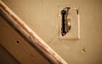 A broken switch plate cover in a stairwell of the home rented by a family in Minneapolis.