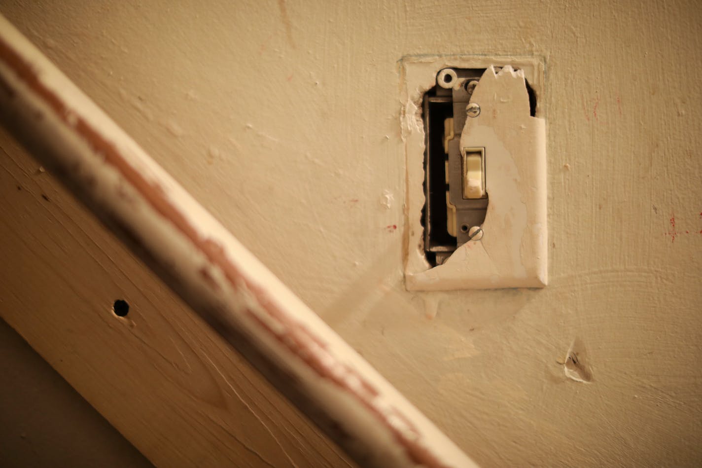 A broken switch plate cover in a stairwell of the home rented by a family in Minneapolis.