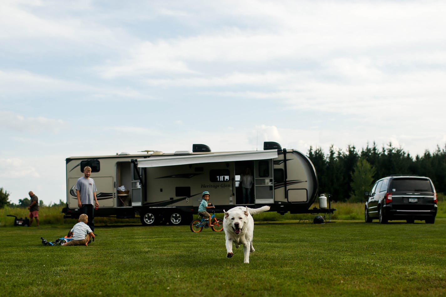 Midway Barker, the Enloe family's dog, runs down the field where they were camping as the family plays at the Enloe family's RV Sunday, August 4, 2019 the evening before they would leave for Iowa. ] NICOLE NERI &#xa5; nicole.neri@startribune.com