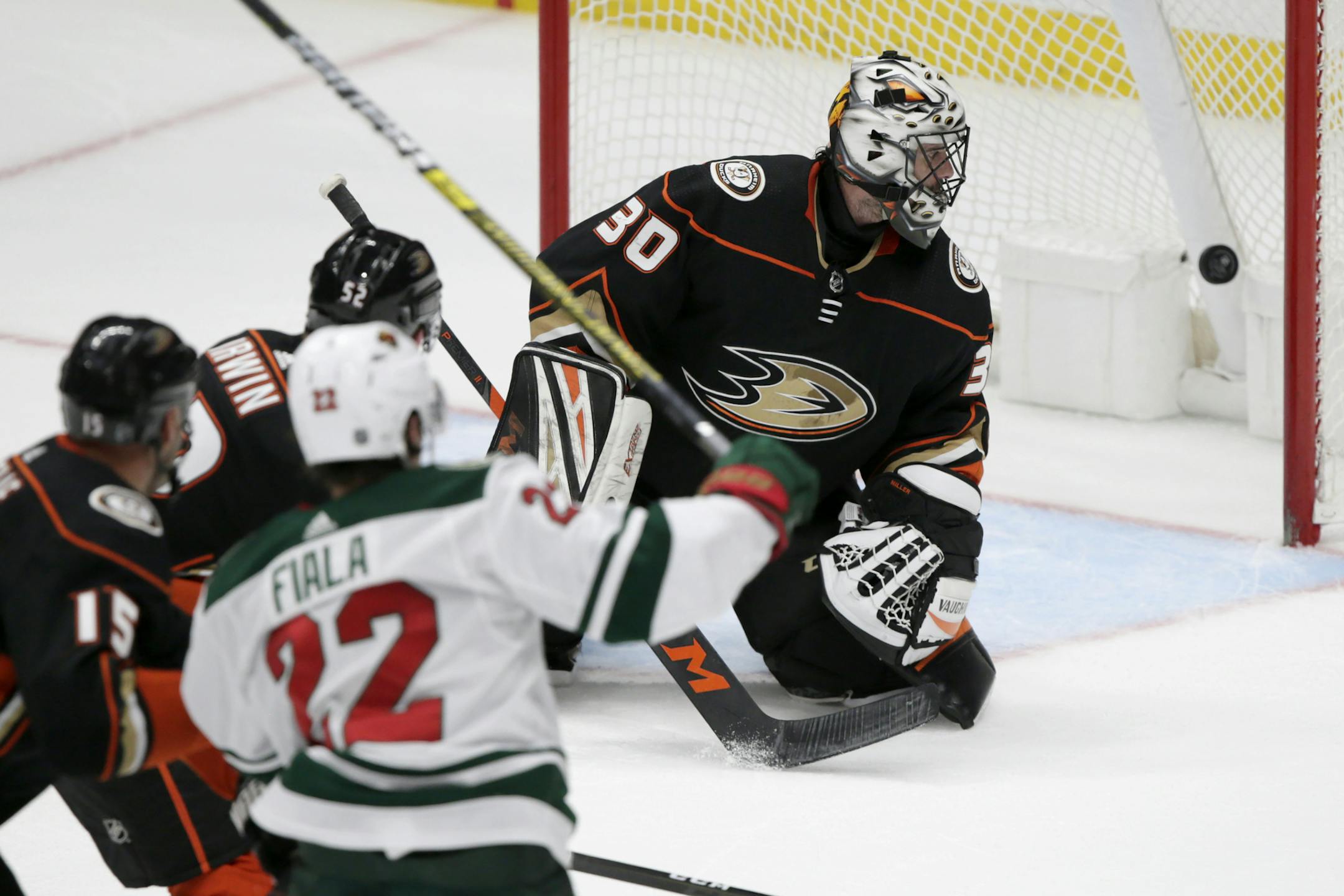 Anaheim Ducks goaltender Ryan Miller, right, watches as the puck gets by for a goal on a shot by Minnesota Wild left wing Kevin Fiala (22), of Switzerland, with center Ryan Getzlaf, left, and defenseman Matt Irwin (52) also watching during the third period of an NHL hockey game in Anaheim, Calif., Sunday, March 8, 2020. The Wild won 5-4. (AP Photo/Alex Gallardo)