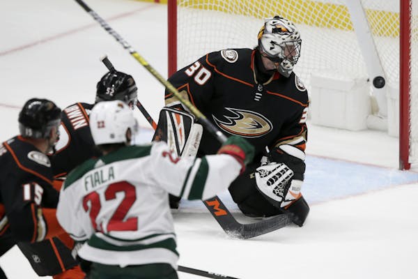 Anaheim Ducks goaltender Ryan Miller, right, watches as the puck gets by for a goal on a shot by Minnesota Wild left wing Kevin Fiala (22), of Switzer