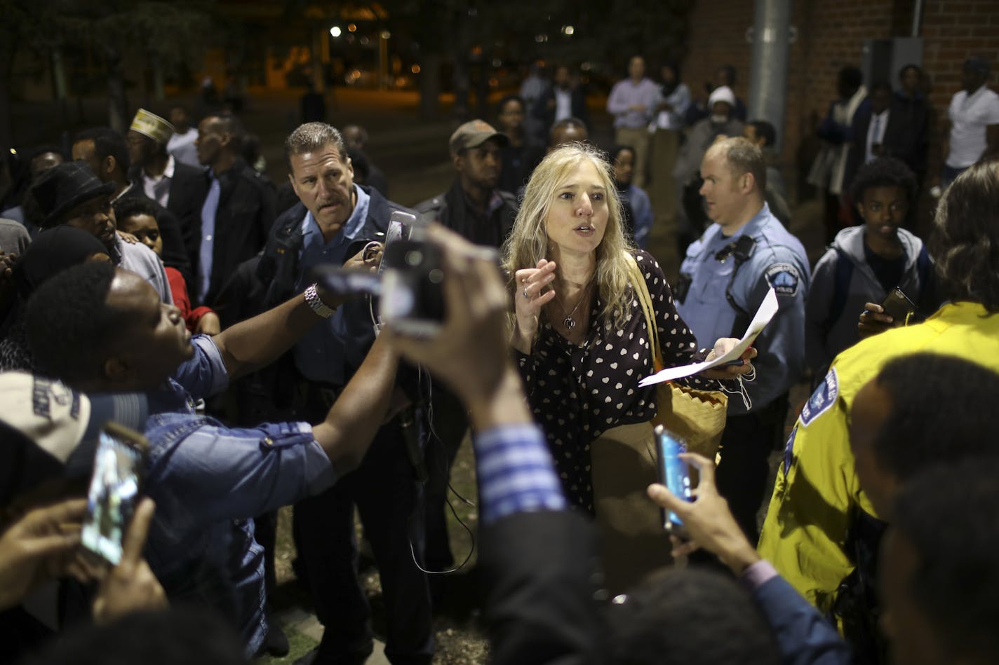 A woman, who refused to identify herself, explains results to caucus goers after a vote was taken to determine delegates in the Sixth Ward.