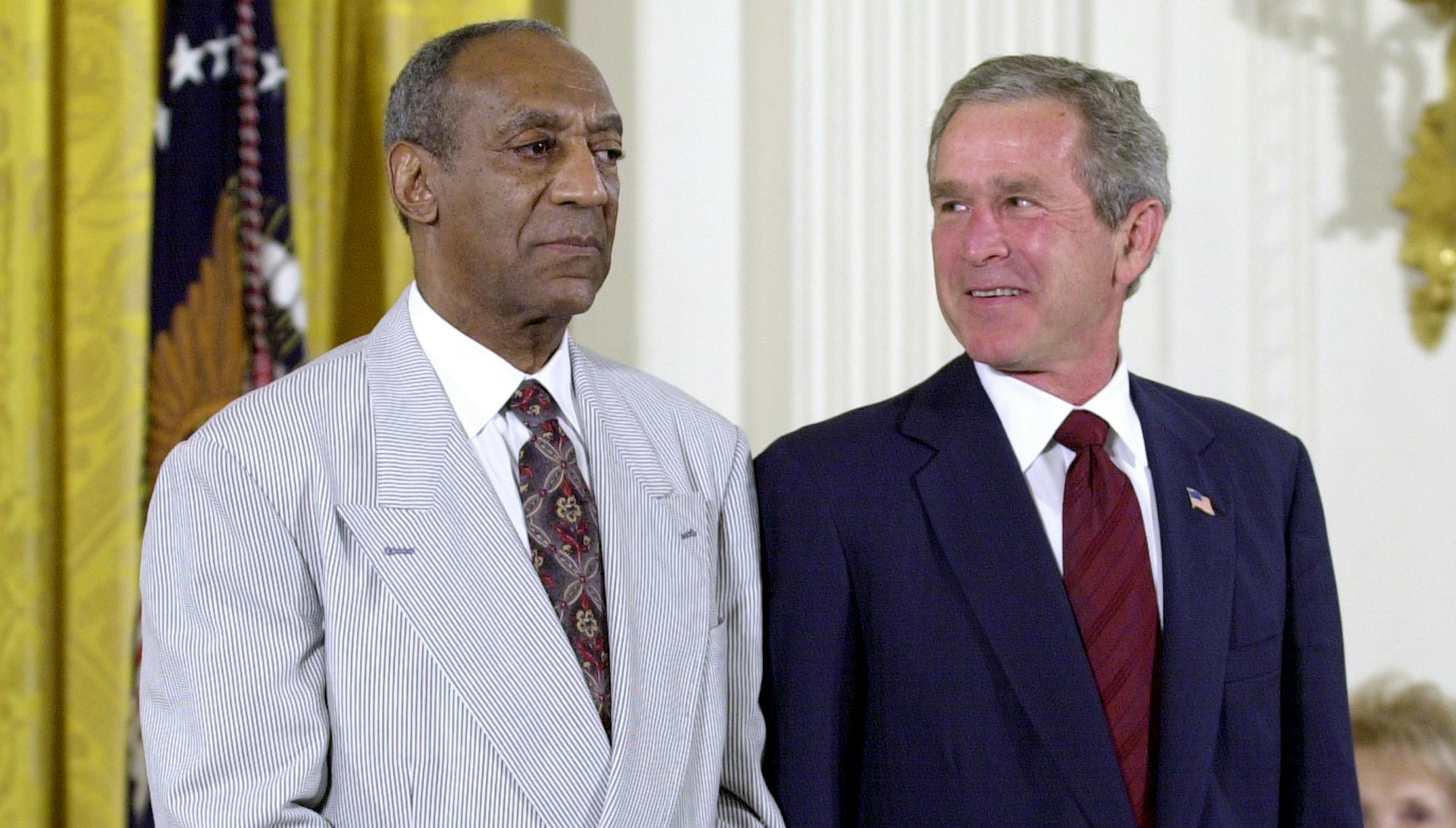 FILE - In this July 9, 2002 file photo, President Bush, right, stands with comedian Bill Cosby during the announcement of Cosby's Presidential Medal of Freedom in the East Room of the White House in Washington. Bush awarded Cosby the nationís highest civilian honor, saying he had ìused the power of laughter to heal wounds and to build bridges.î (AP Photo/Kenneth Lambert, File) ORG XMIT: MIN2015072713510124