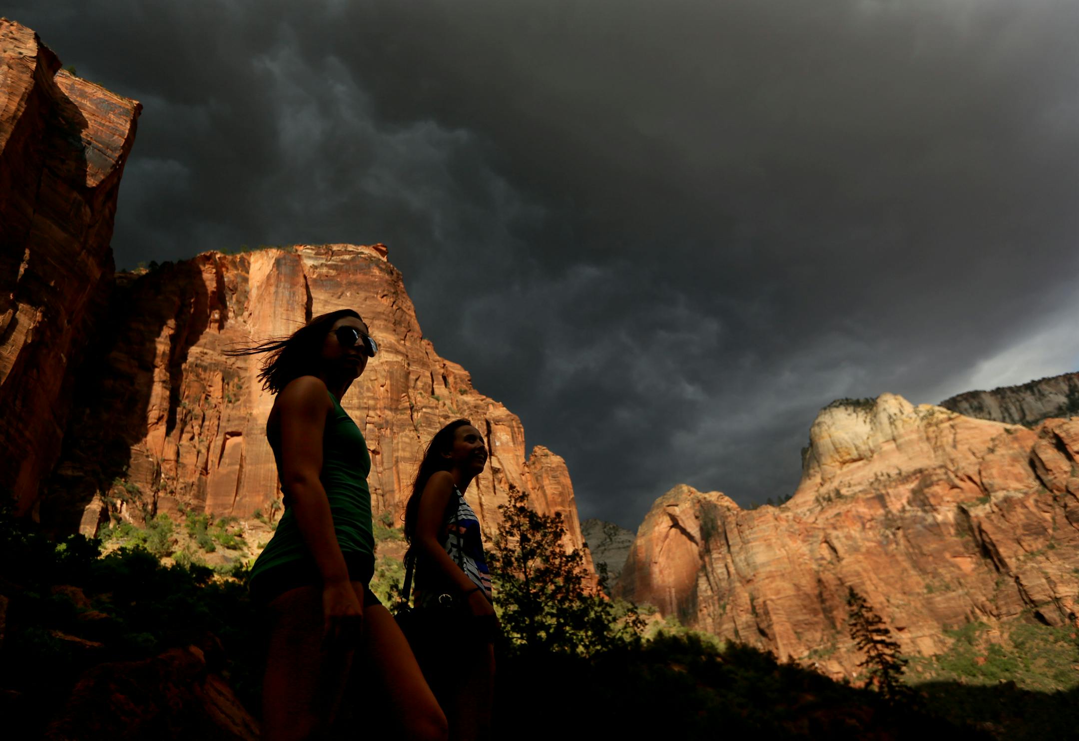 Hikers look up at a fast moving storm as it makes its way through Zion National Park outside of Springdale, Utah.