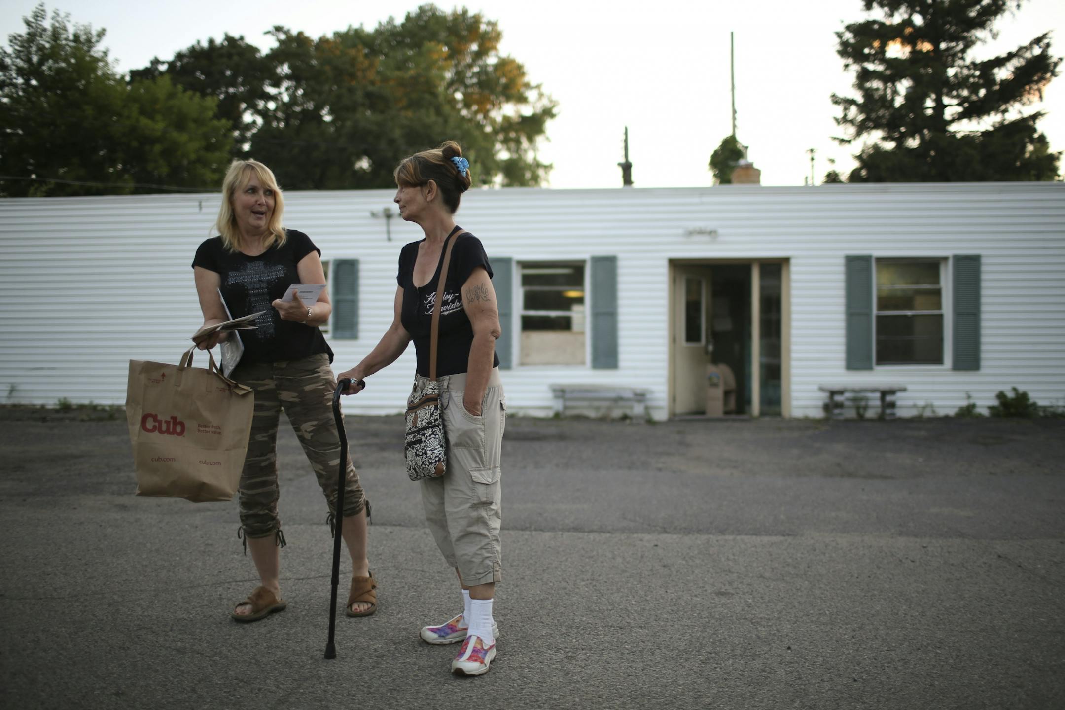 Luann Zappa, left, laughed about some junk mail she received after picking up her mail while out for a walk with Doreen Mitchell Thursday evening.