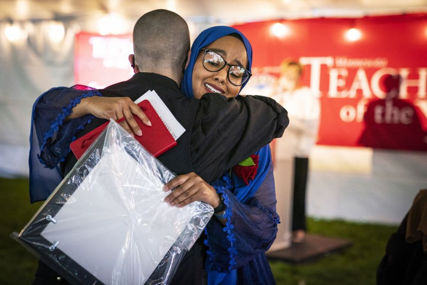 Qorsho Hassan, a fifth grade teacher at Gideon Pond Elementary School in the Burnsville-Eagan-Savage School District, Education Minnesota's 2020 Teacher of the Year, gets a hug from 2018 Teacher of the Year Kelly D. Holstine during a ceremony at the State Capitol, Thursday, Aug. 6, 2020, in St. Paul, Minn.