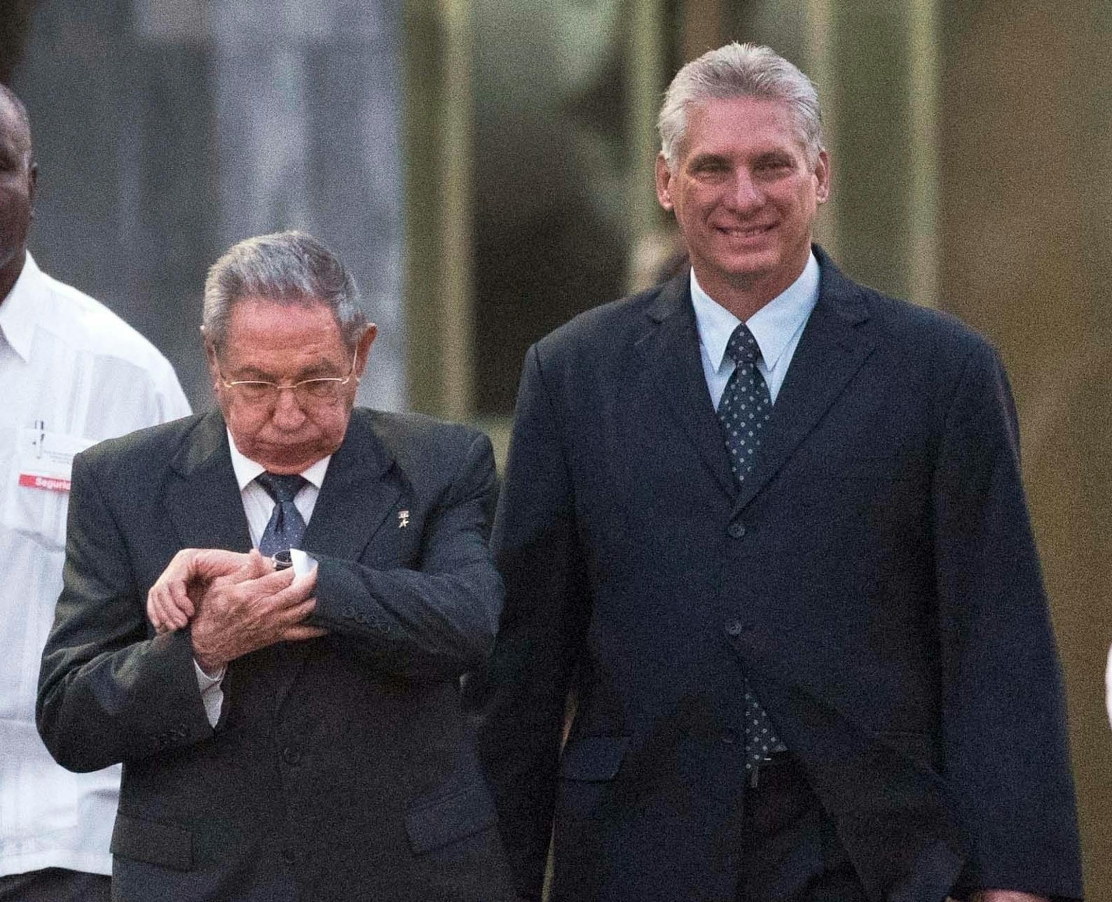 FILE - In this Jan. 28, 2018 file photo, Cuba's President Raul Castro looks at his watch as he walks with Cuba's Vice President Miguel Diaz-Canel Bermudez, right, and National Assembly of People's Power President Esteban Lazo Hernandez, left, to the unveiling of a replica of a statue of Cuba's independence hero Jose Marti in Havana, Cuba. The greatest immediate challenge for Castroís expected successor, 57-year-old Diaz-Canel, is unwinding a byzantine dual-currency system featuring one type