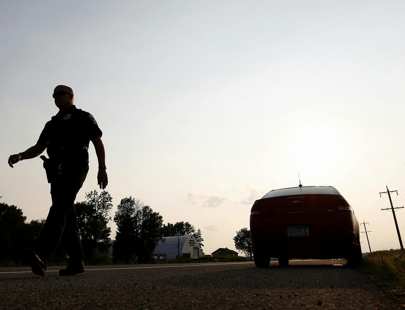 Lino Lakes police officer Adam Halverson walked back to his vehicle as he conducted a traffic stop on Monday. Officer Halverson has more than 500 stops in past two months. ] CARLOS GONZALEZ cgonzalez@startribune.com - August 31, 2015, Lino Lakes, MN, Adam Halverson is on his way to becoming the most well-known police officer in Lino Lakes. Lino Lakes new traffic cop who is making waves with more than 500 stop in his first two months.