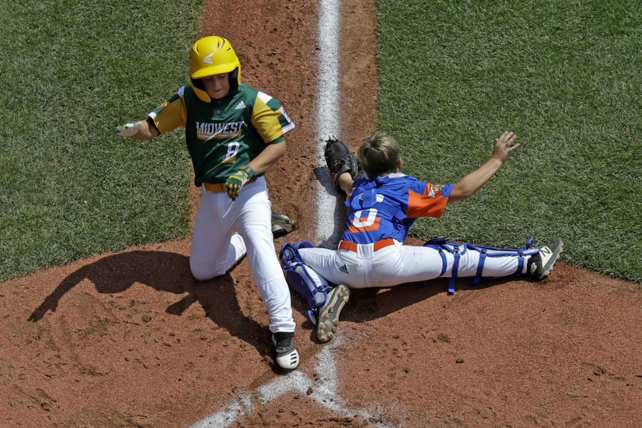 Coon Rapids, Minnesota's Dylan Bloom (8) scores past Bowling Green, Kentucky's catcher Sol Guyer (6) stretches for the relay throw during the second inning of a baseball game at the Little League World Series tournament in South Williamsport, Pa., Friday, Aug. 16, 2019. Minnesota won 2-1.