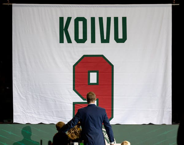 Mikko Koivu and his children watch his number lifted into the rafters during a ceremony Sunday at Xcel Energy Center.