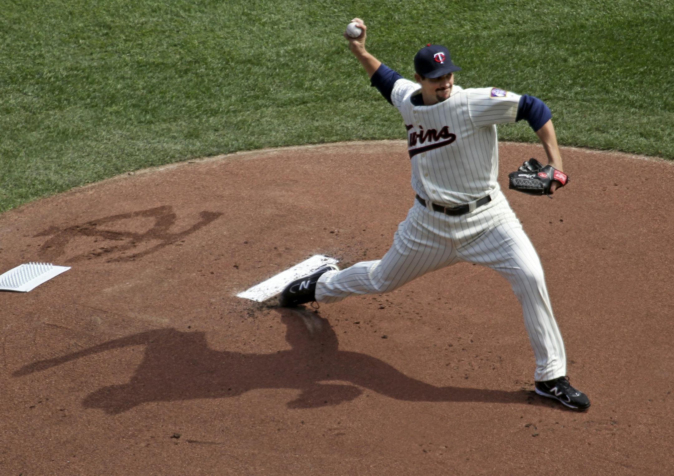 Twins starter Carl Pavano delivers the game's first pitch.