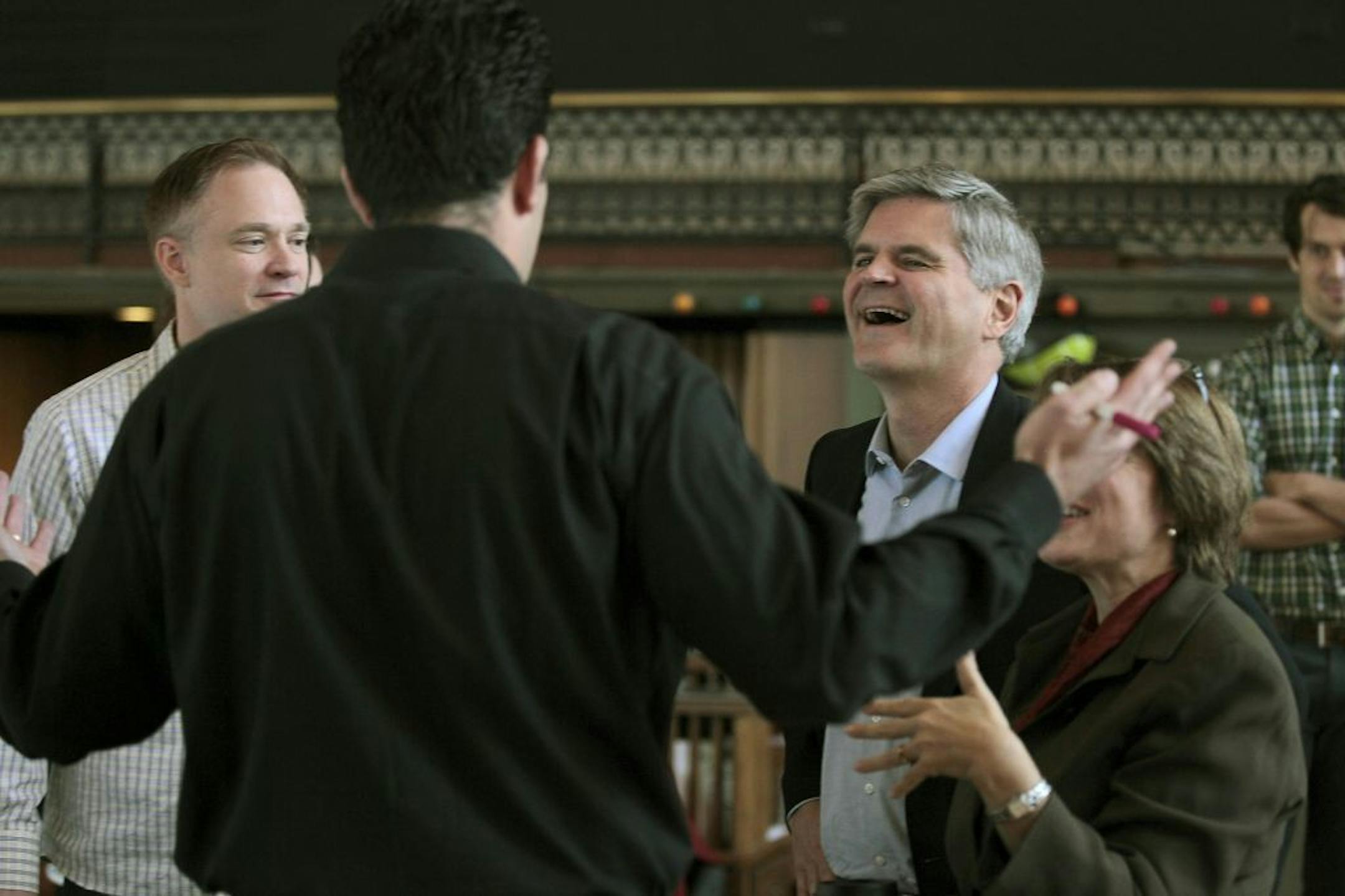 AOL.com founder and startup-business promoter Steve Case, center, and Senator Amy Klobuchar, right, listened to Colin Hirdman, left, and Josh Becerra's business pitch at CoCo's "startup fair," Tuesday, October 7, 2014 at the former Grain Exchange floor in downtown Minneapolis, MN. Case is visiting several cities as part of his "Rise of the Rest Road Tour," where he will invest $100,000 in a new business.