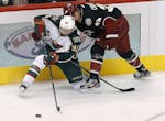 Minnesota Wild's Pierre-Marc Bouchard passes the puck as Phoenix Coyotes' Kyle Chipchura defends.