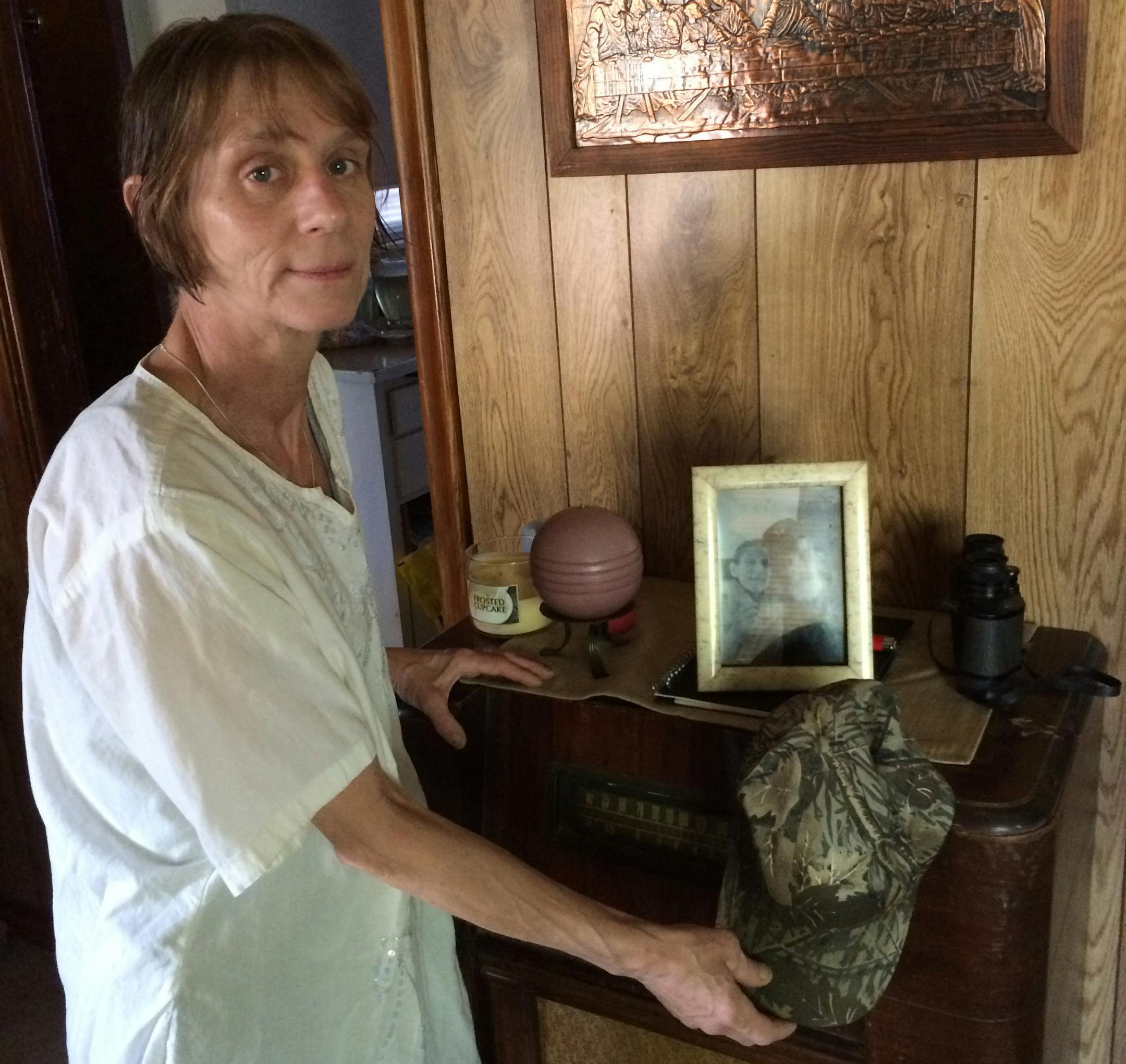 Sheila Van Epps with her beloved Joe Eder’s hat in their house in Robbinsdale; a framed photo of them is in the background.