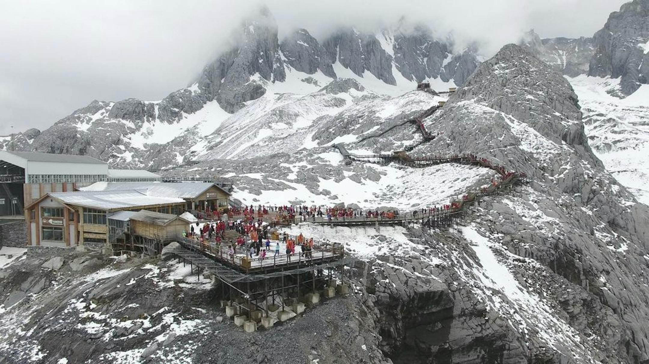 In this photo taken May 2018, and released by Yulong Snow Mountain Glacier and Environmental Observation Research Station on Oct. 18, 2018, tourists gather on a platform above the Baishui Glacier No.1 on the Jade Dragon Snow Mountain in the southern province of Yunnan in China. Scientists say the glacier is one of the fastest melting glaciers in the world due to climate change and its relative proximity to the Equator. It has lost 60 percent of its mass and shrunk 250 meters since 1982.