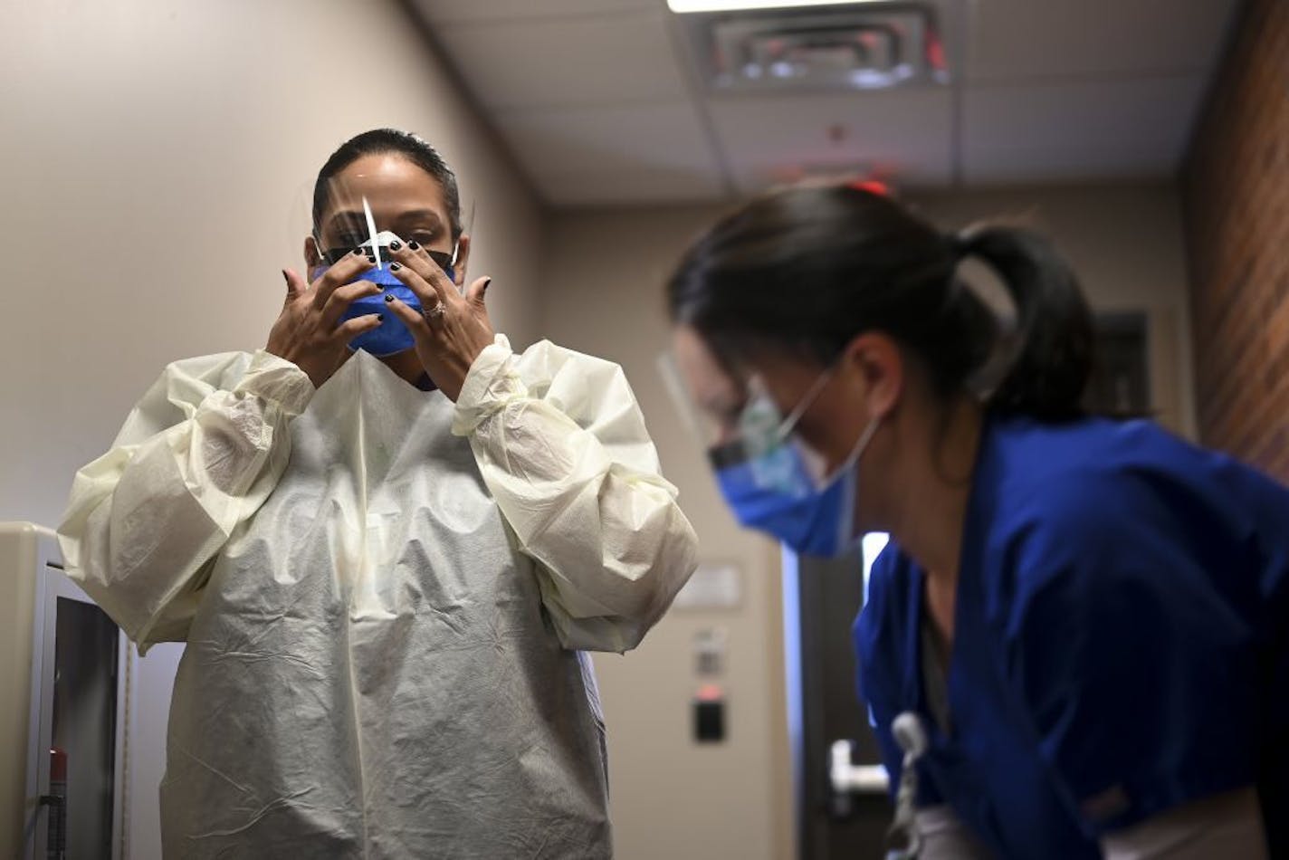 M Health Fairview medical assistants Reece Wallaker, left, and Sandy Graves, put on protective equipment as they demonstrated drive-up COVID-19 testing. M Health Fairview is converting the Bethesda long-term care hospital in St. Paul into a COVID-19 treatment center.