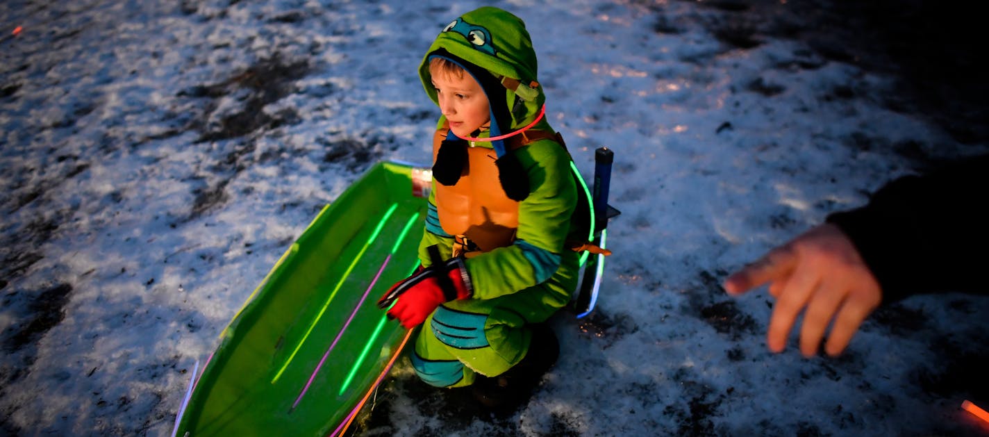 Daniel Gangi, 6, of St. Paul Park, got some sledding advice from his father before going down the hill behind St. Paul Park City Hall Wednesday night. ] (AARON LAVINSKY/STAR TRIBUNE) aaron.lavinsky@startribune.com More than 100 young sledders took part in St. Paul's "Glow in the Dark" sledding event behind St. Paul Park City Hall on Wednesday, Dec. 28, 2016. Despite icy conditions on the hill, children decorated their sleds with lights and glow in the dark accessories with an award going to the