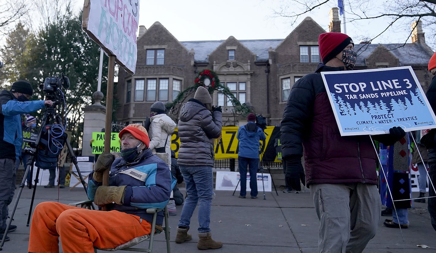 Protesters demonstrate outside the governor's residence about the adequacy of Enbridge's virus plans.