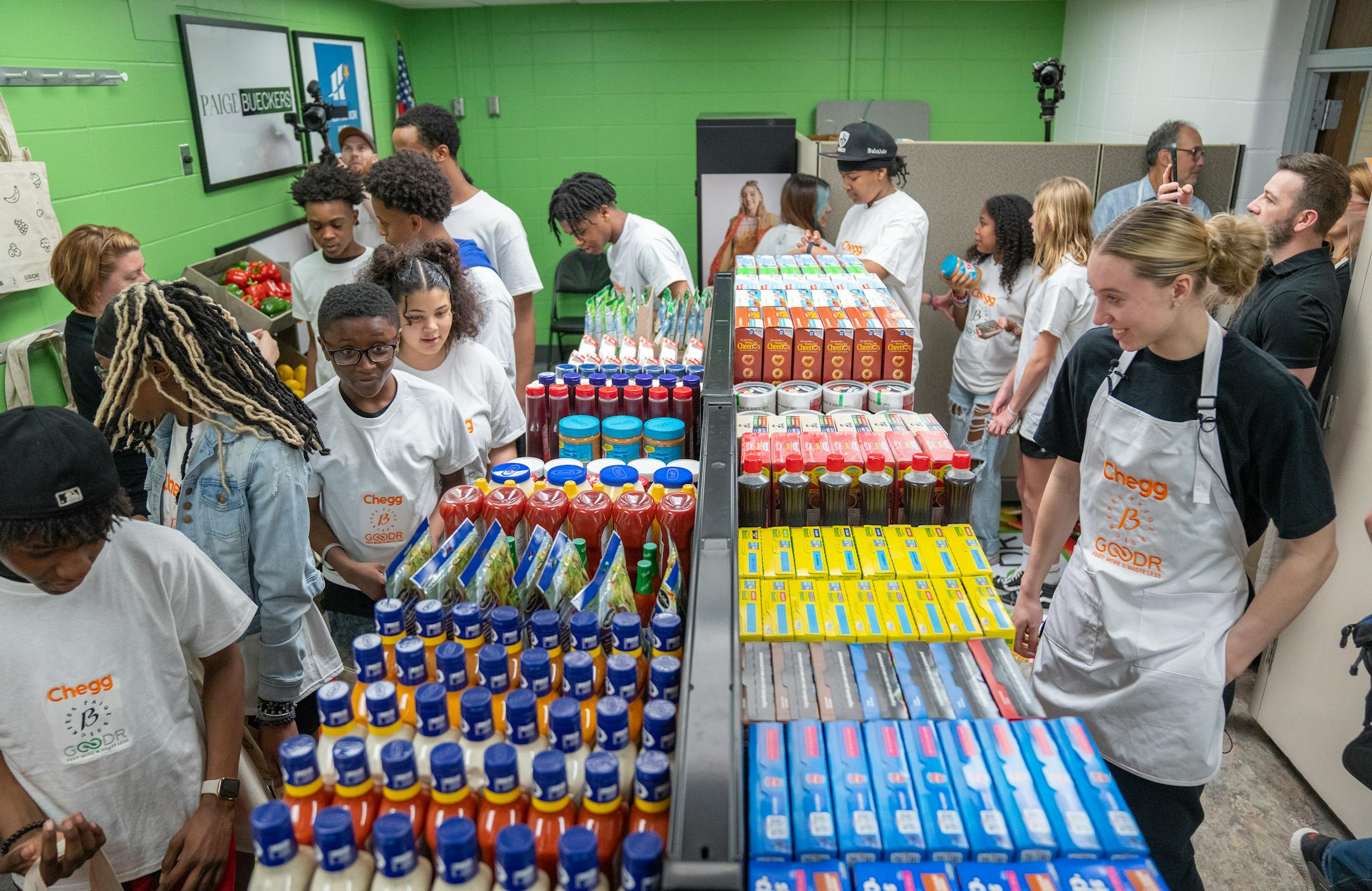 Paige Bueckers walks and talks with students during the grand opening of a new free grocery store.
