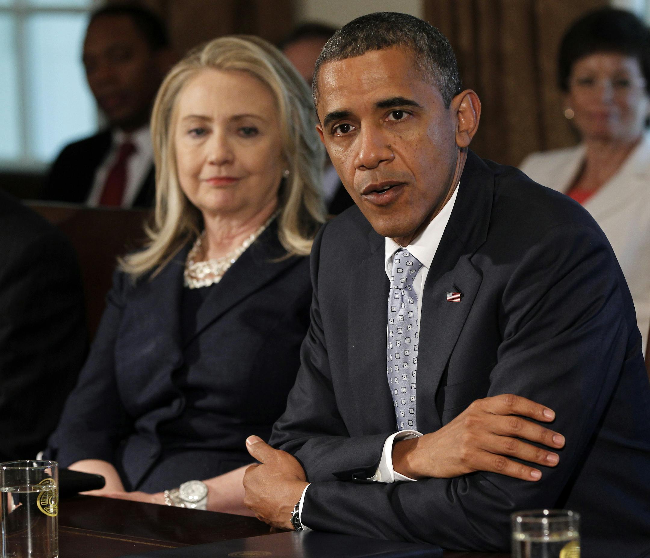 Secretary of State Hillary Rodham Clinton listens at left as President Barack Obama speaks to members of the media during a Cabinet Meeting in the Cabinet Room of the White House in Washington, Thursday, July, 26, 2012. (AP Photo/Pablo Martinez Monsivais)