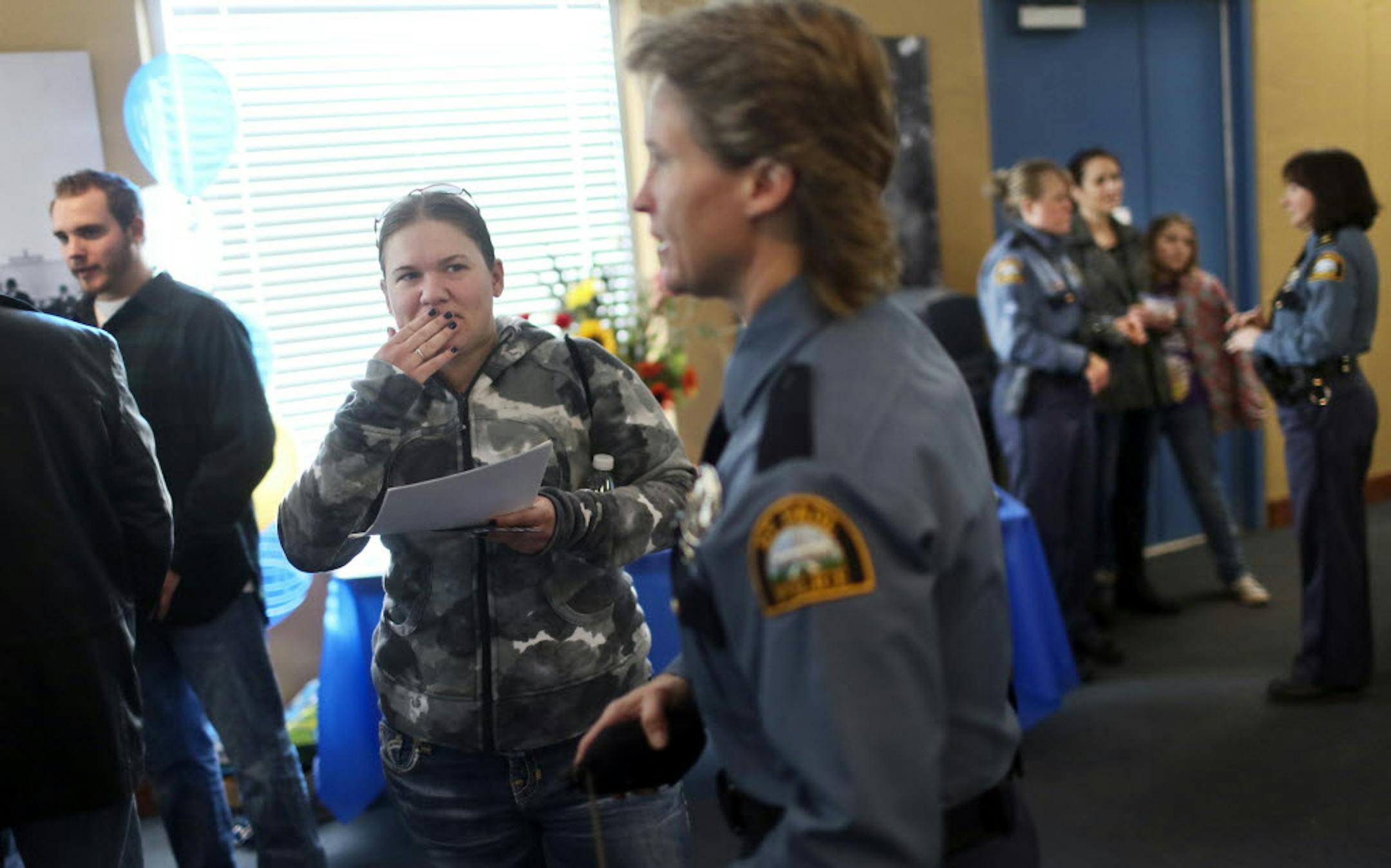 Alysha Huber of Oakdale, left, who is interested in a career in law enforcement, listened to St. Paul police investigator Diana Olsem talk about departmental opportunities during a job fair Saturday.
