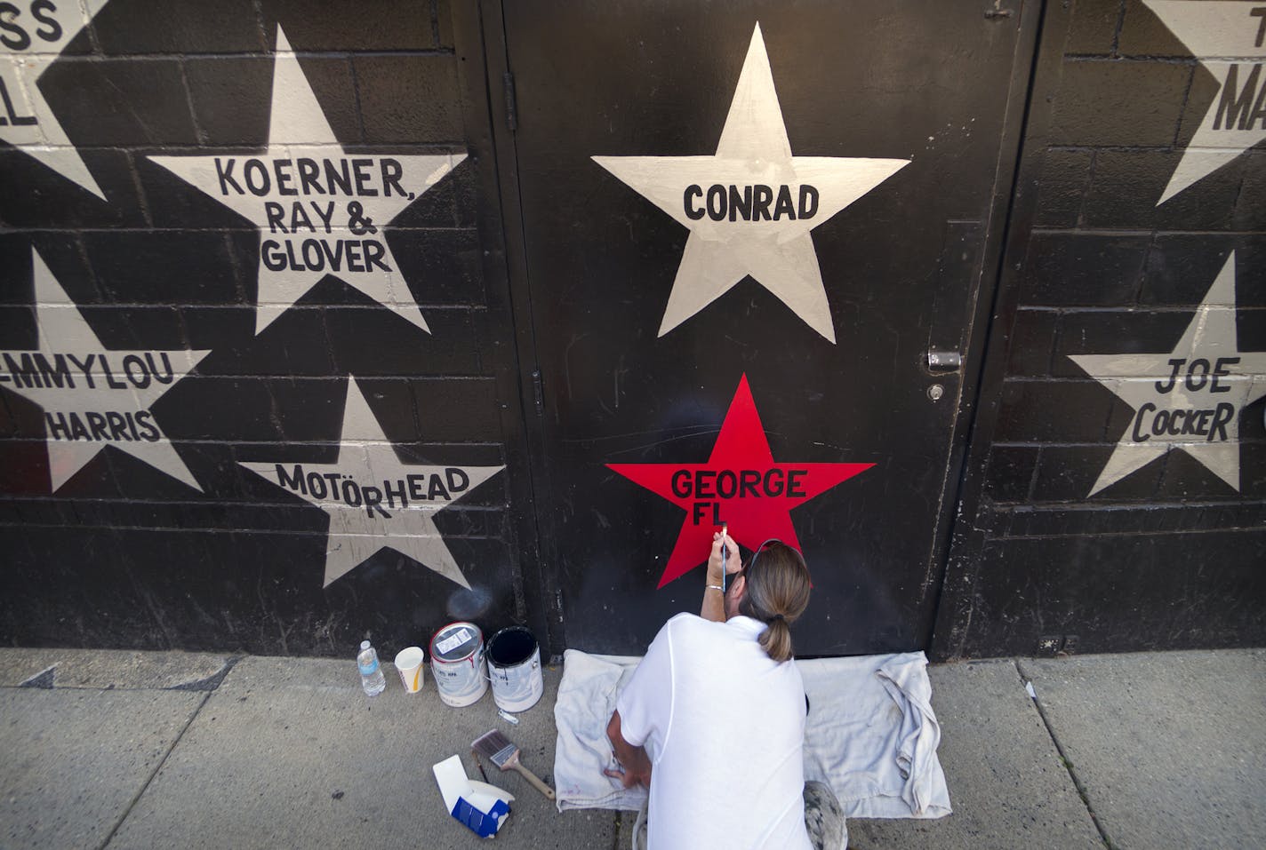 First Avenue nightclub's iconic star facade is getting its once-per-decade paint job this week, but with a couple sign-of-the-times twists: Due to pandemic-related budget constraints, the entire building will not be repainted as usual. One new star is being added with George Floyd's name on it painted in red. The marquee is also getting a makeover back to the skyline-style logo the building had in the "Purple Rain" era. Here, Kory Lidstrom, owner of Indy Painting, adds Greoge Floyd's name to a r