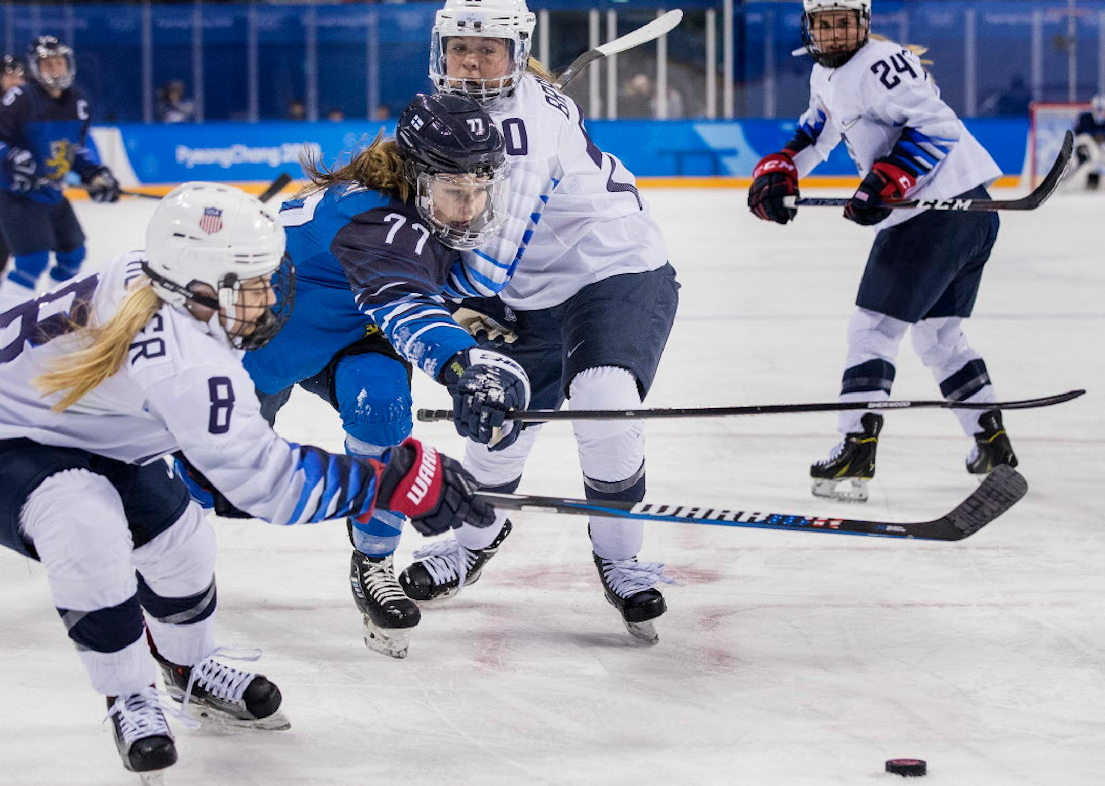 Emily Pfalzer (8) Susanna Tapani (77) and Hannah Brandt (20) fought for the puck in the first period of the U.S.-Finland game.