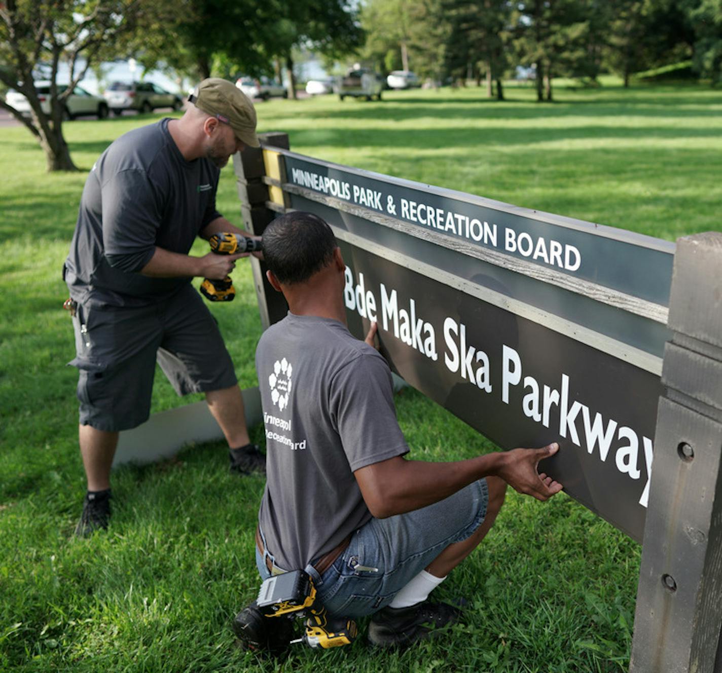 Minneapolis Park and Recreation Board (MPRB) workers install new placards changing East and West Lake Calhoun Parkways to East and West Bde Maka Ska Parkways. ] brian.peterson@startribune.com Minneapolis, MN Thursday, August 22, 2019