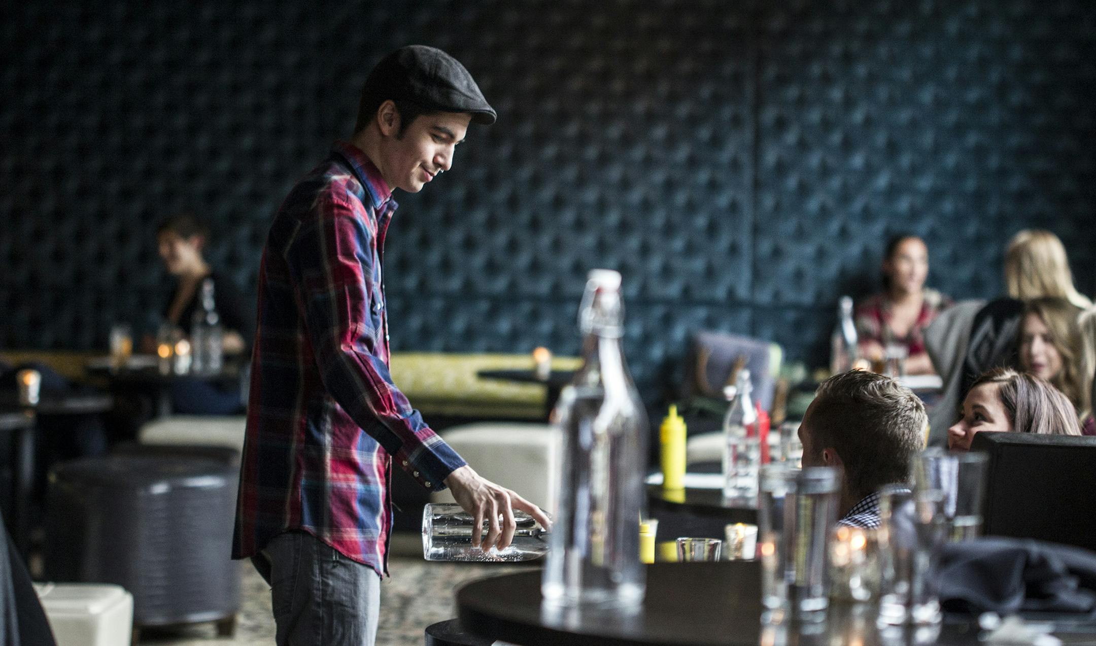 Troy Cleven fills water glasses at Parlour in Minneapolis March 25, 2015. (Courtney Perry)