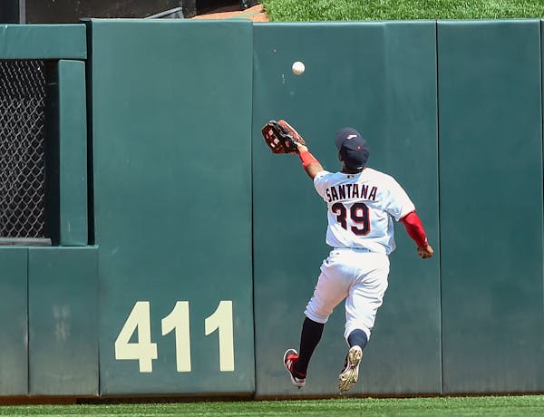 Minnesota Twins center fielder Danny Santana misses a fly ball hit by Cleveland Indians' Abraham Almonte and ruled a double after bouncing over the fe