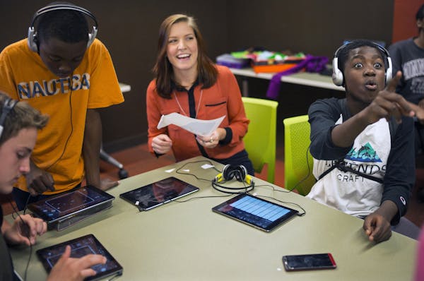 At the Maplewood library, Jana Greenslit(center) an Americorps mentor was chatting with the kids who were creating catchy tunes in Garage Band. (l to 
