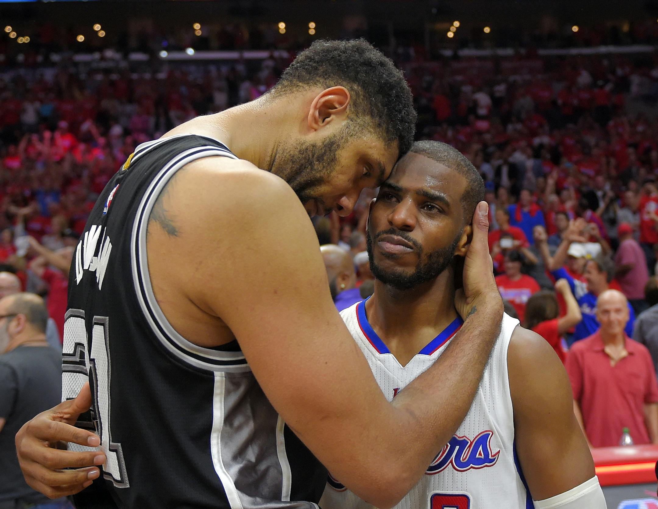 San Antonio Spurs forward Tim Duncan, left, hugs Los Angeles Clippers guard Chris Paul after the Clippers won Game 7 in a first-round NBA basketball playoff series, Saturday, May 2, 2015, in Los Angeles. The Clippers won 111-109. (AP Photo/Mark J. Terrill)