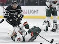 Minnesota Wild defenseman Matt Dumba falls to the ice in front of of Los Angeles Kings center Torrey Mitchell during the first period of an NHL hockey