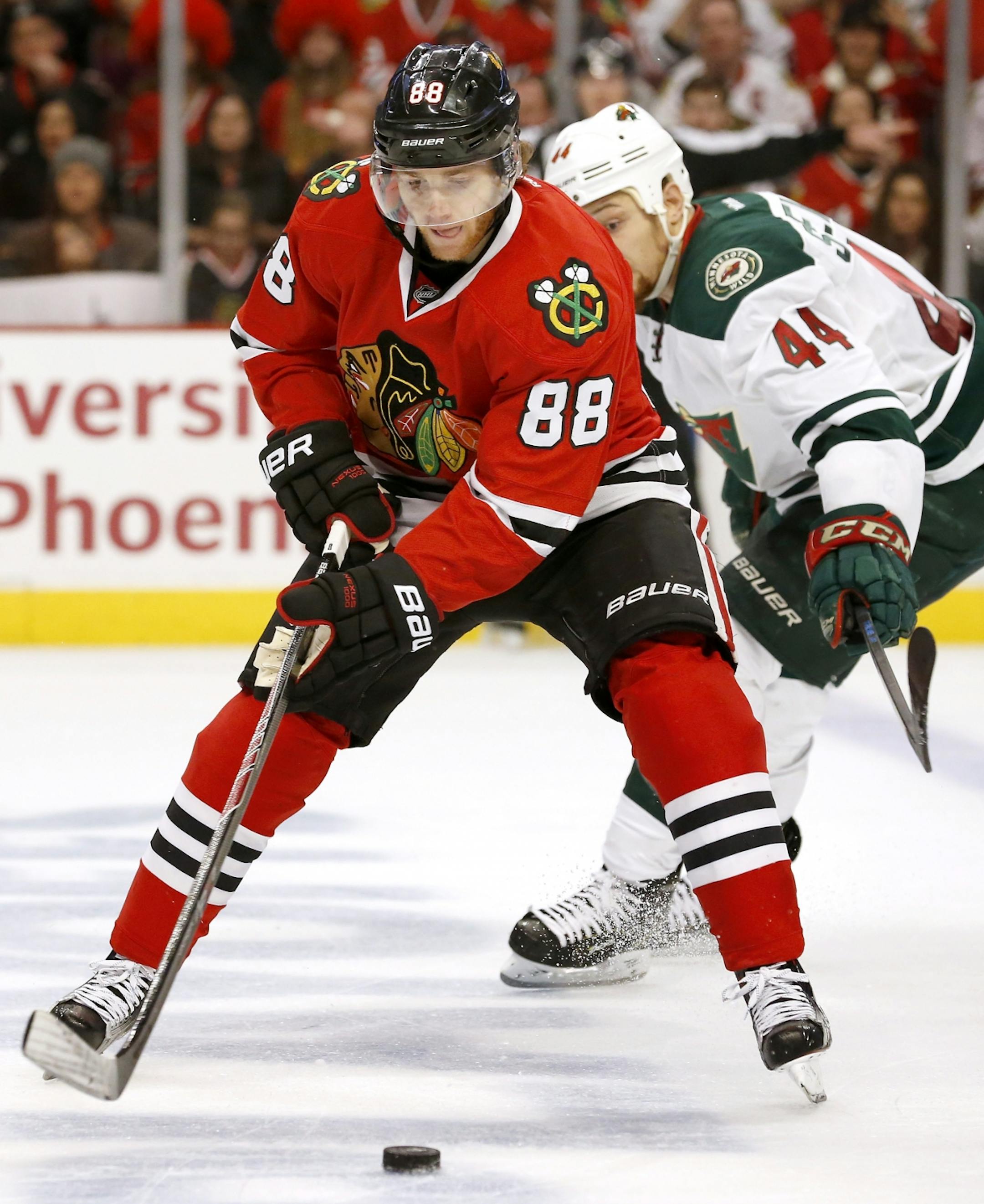 Patrick Kane (88) and Chris Stewart (44) fought for the puck in the second period.