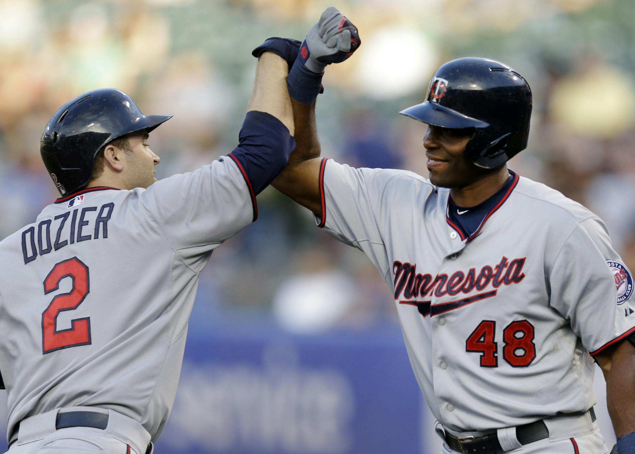 Minnesota Twins' Brian Dozier, left, is congratulated by teammate Torii Hunter (48) after hitting a home run off Oakland Athletics' Sonny Gray in the first inning of a baseball game Friday, July 17, 2015, in Oakland, Calif. (AP Photo/Ben Margot)