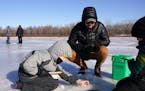 Erich Nell of Minneapolis watched as his stepsons Sullivan Maland, 6, and Harrison Maland, 9, tried their hand at ice fishing during Winter Trails day