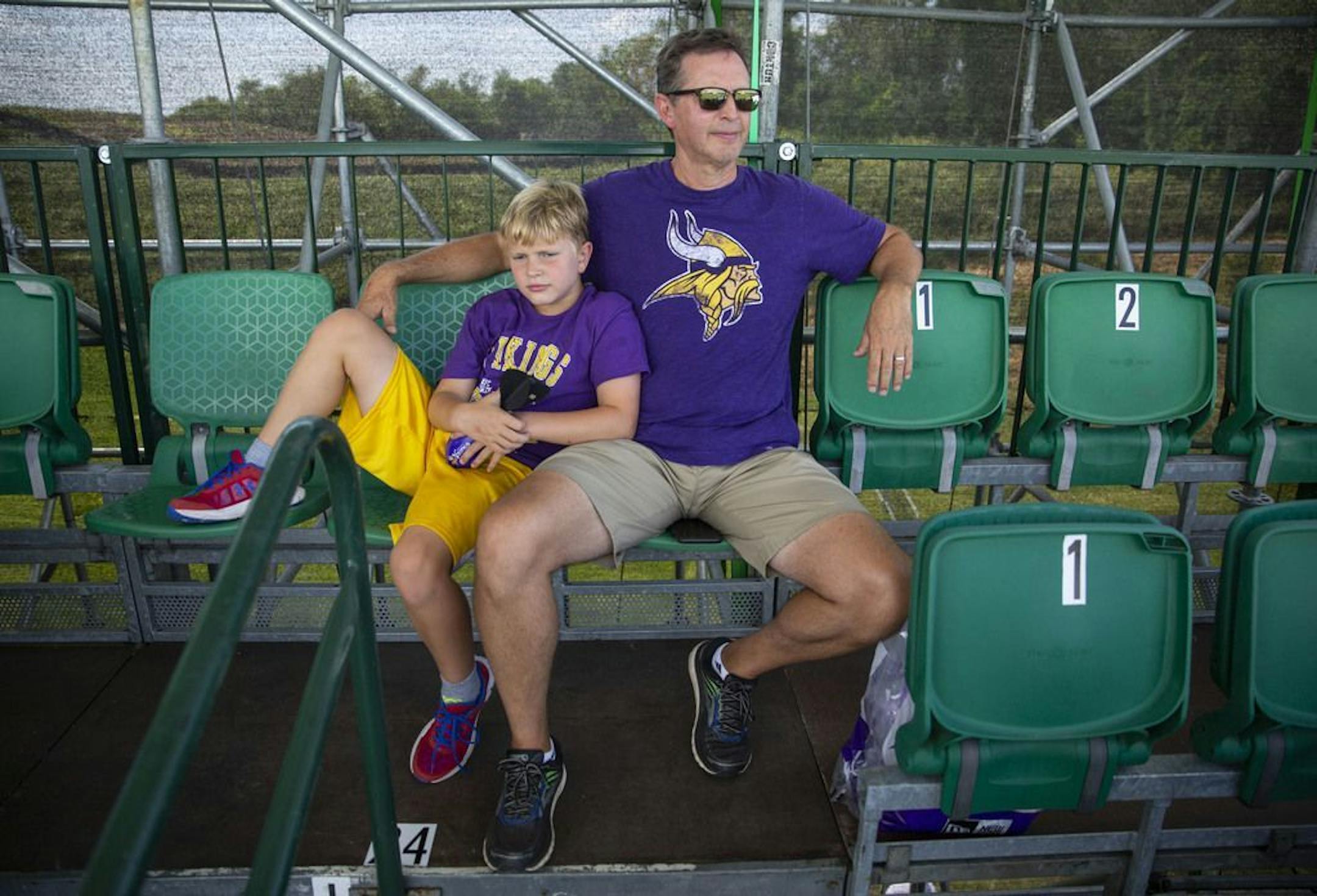 (Left) Jake and Scott McCuddin lounged in the shade at the top of the grandstands and watched the Vikings first full practice on Friday. ALEX KORMANN • alex.kormann@startribune.com The Minnesota Vikings opened up their first full day of training camp on Friday July 26, 2019 at TCO Performance Center in Eagan, MN. Doors opened to fans at 11AM to watch their favorite players practice and get excited for the 2019 NFL season.