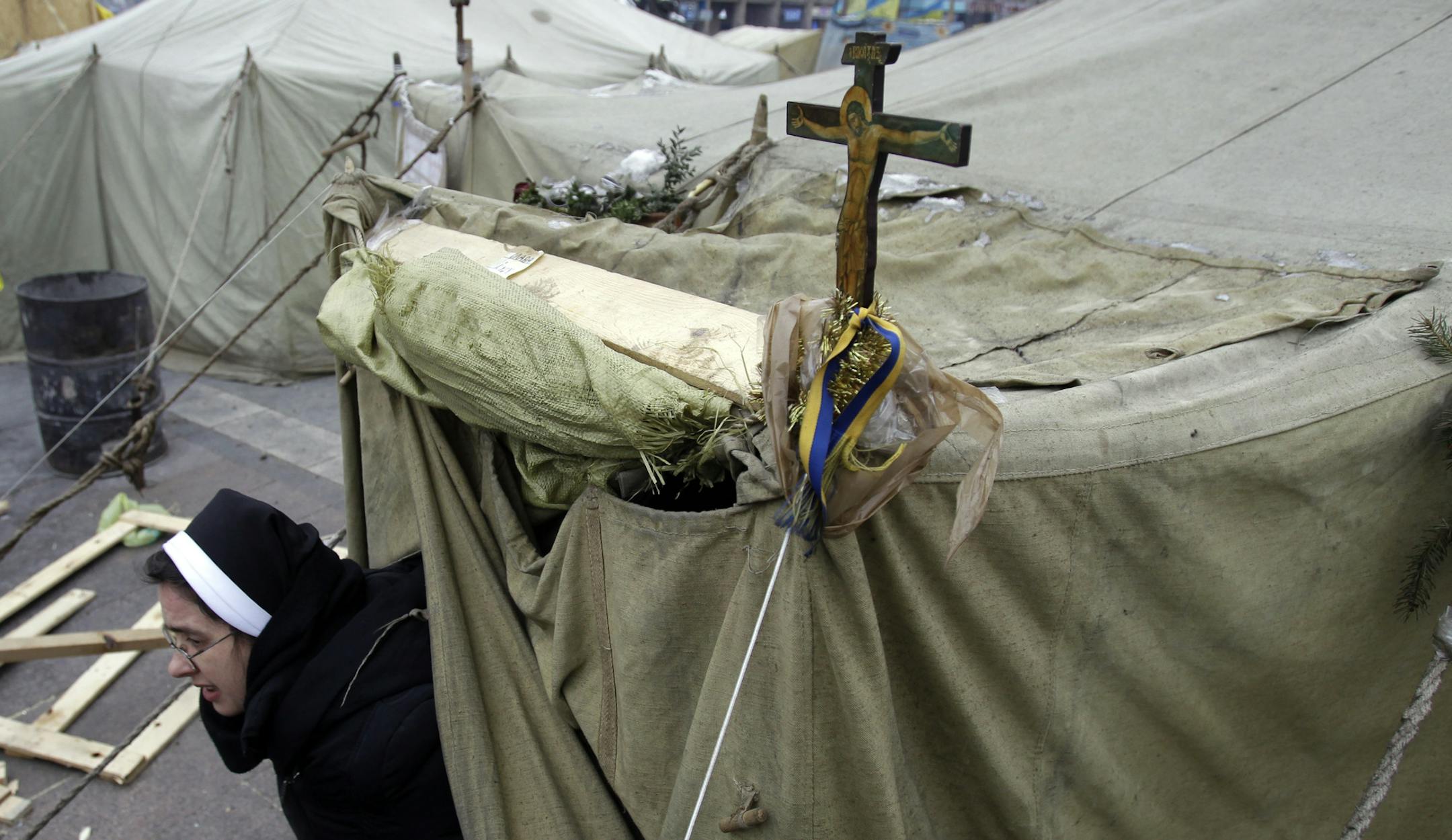 A nun on Tuesday left a tent that is being used as a church in Independence Square in Kiev. Key issues remain unresolved in the political crisis, including demands that President Viktor Yanukovych resign.