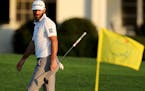 Dustin Johnson looks over his shot on the 18th green during the third round of the Masters