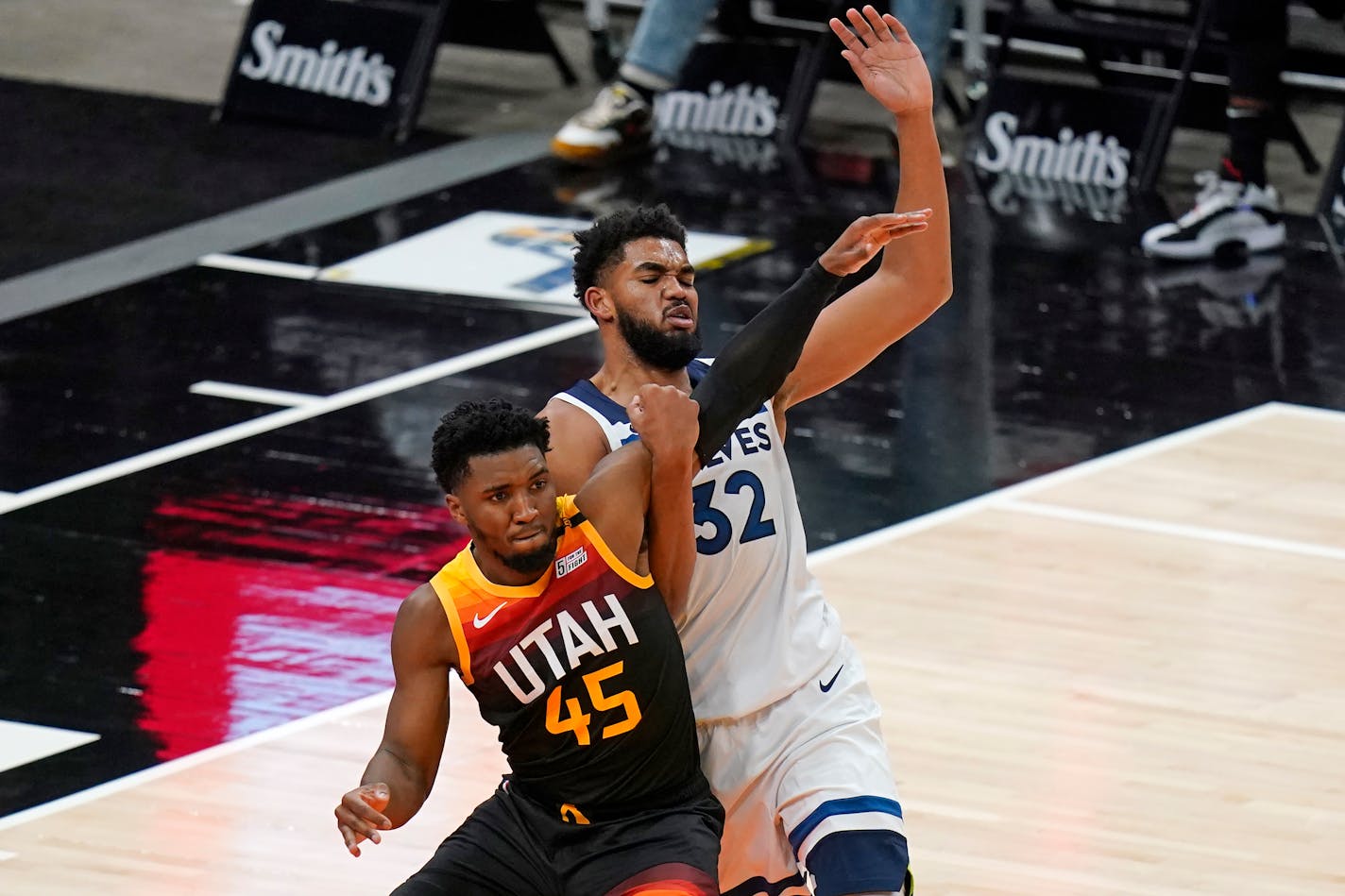 Utah Jazz guard Donovan Mitchell (45) and Minnesota Timberwolves center Karl-Anthony Towns (32) battle for position under the boards during the second half of an NBA basketball game Saturday, Dec. 26, 2020, in Salt Lake City. (AP Photo/Rick Bowmer)