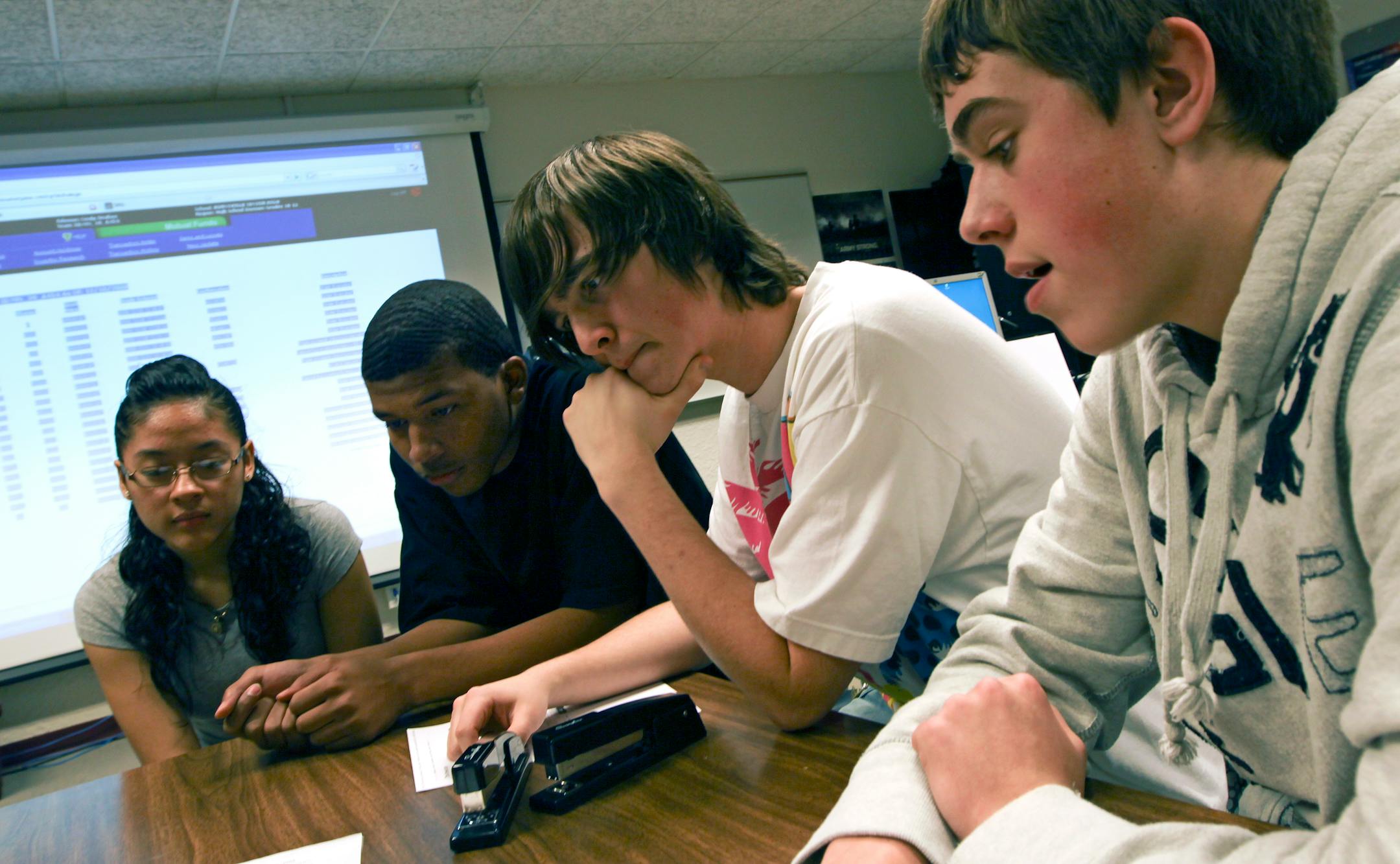 Burnsville High School Stock Market Game teammates, from left, Lois Gutierrez, Collione Malone, Kevin Phyle and Adam Smyth crunched some numbers as they considered ways to invest their fantasy $100,000 in stock picks.