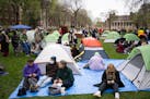 Demonstrators study and visit after setting up tents on the lawn. A few hundred people gathered outside Coffman Memorial Union to call for a cease-fir