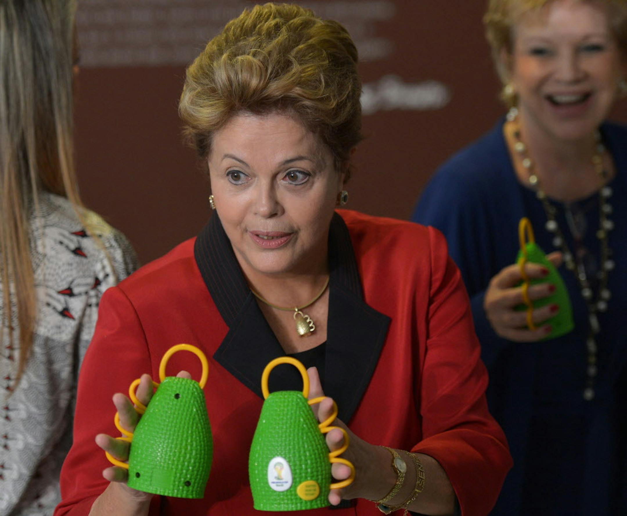 In this file photo from April 22, 2013, released by Agencia Brasil, Brazil's President Dilma Rousseff holds caxirolas during their official presentation at the Planalto Palace, in Brasilia, Brazil. The hand-sized caxirola is based on the African instrument caxixi, which is played during the Capoeira, a popular afro-Brazilian martial art. The official noisemakers for next year's World Cup soccer tournament in Brazil will be significantly quieter than the vuvuzela horns that caused so many headach