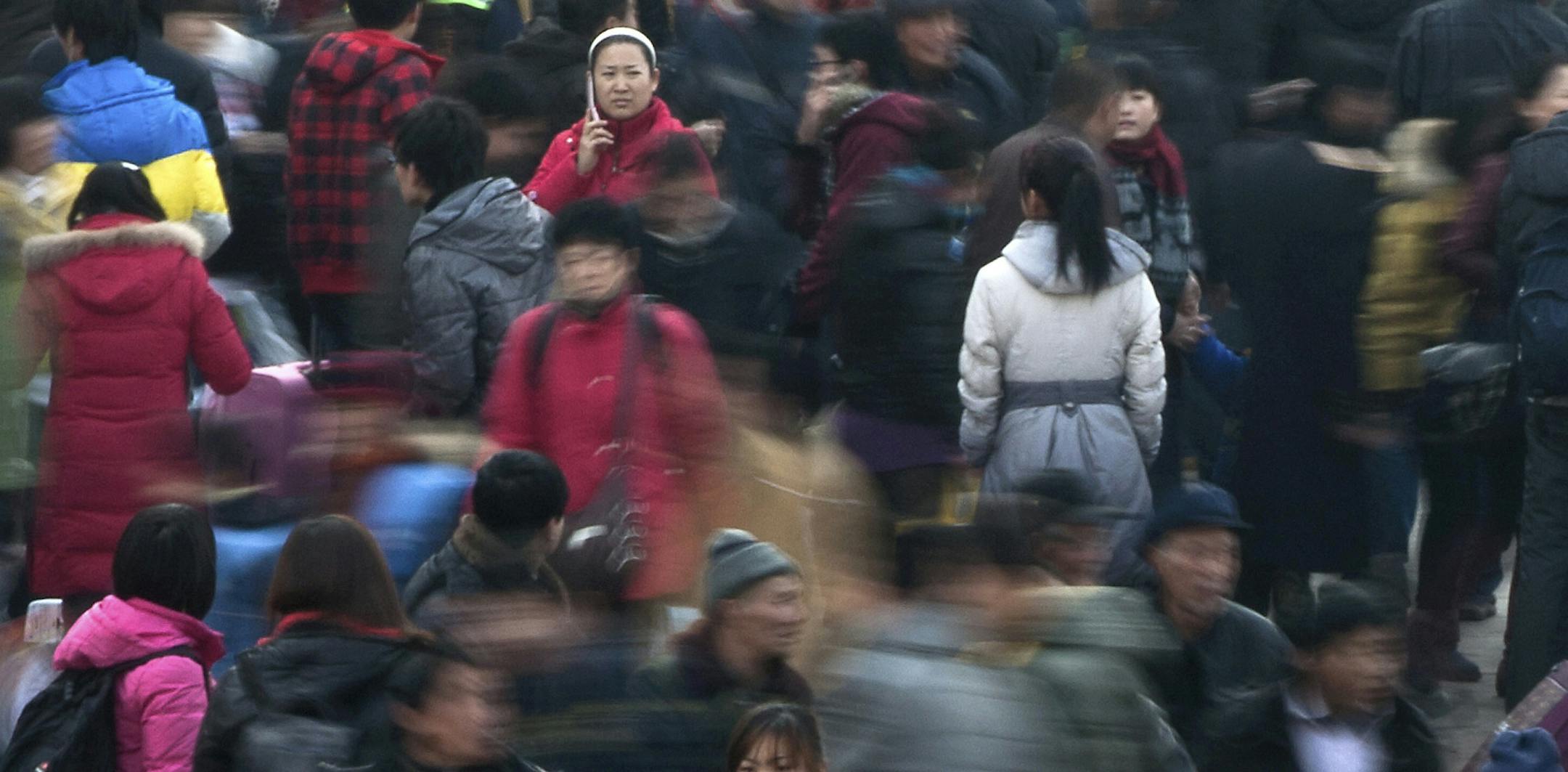 FILE - In this Jan. 8, 2012 file photo, people rush to catch their train at Beijing station in Beijing, China as millions of Chinese are expected to cramp onto China's train network in the coming weeks to return home for the Chinese lunar new year. Beijing's city government said Sunday, July 12, 2015 that it is going to move part of its administrative functions out of the city center as part of a plan to better integrate the Chinese capital with its surrounding areas. The municipal government's