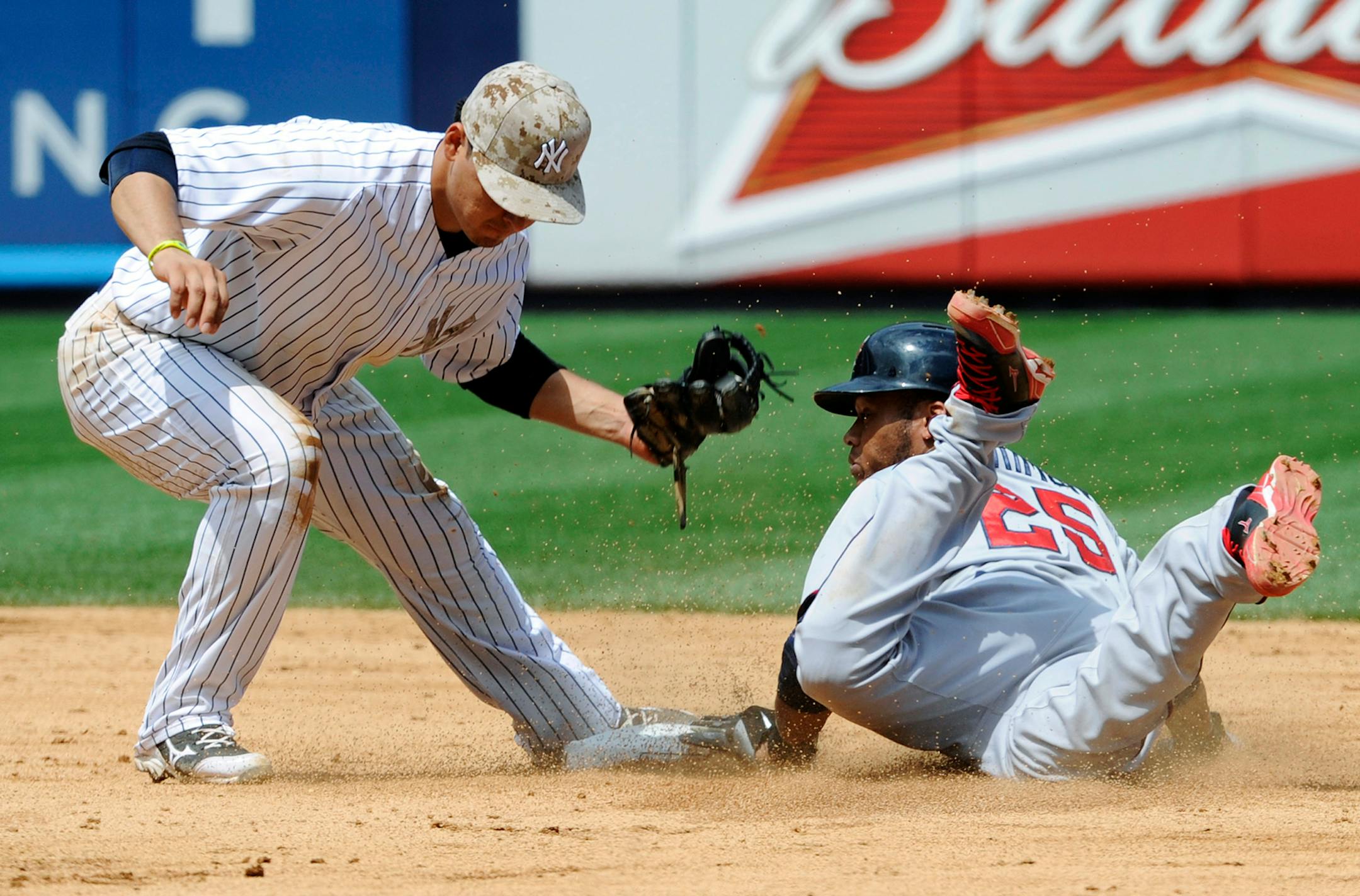 New York Yankees shortstop Luis Cruz, left, tags out Minnesota Twins' Pedro Florimon on an attempted steal of second base during the sixth inning of a baseball game Saturday, July 13, 2013, at Yankee Stadium in New York.