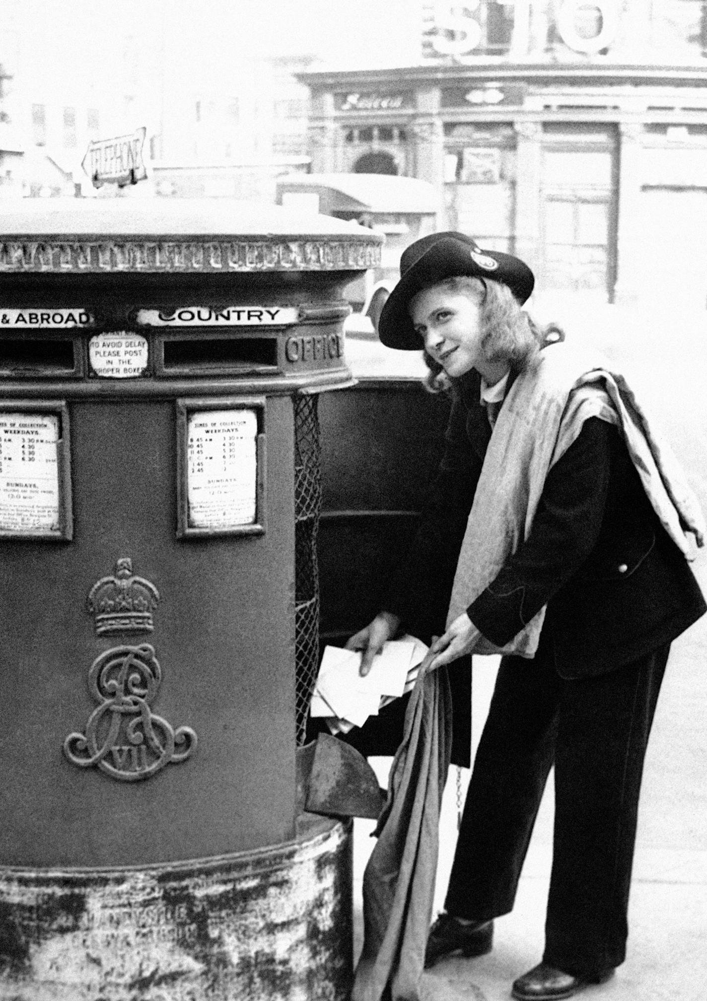 A London postwoman, wearing slacks and a nifty hat, collects letters from a corner mailbox in London, Nov. 30, 1942. Because of the need for men in the armed services and in production factories, London women are doing many jobs formally held by men. (AP Photo) ORG XMIT: APHS346055