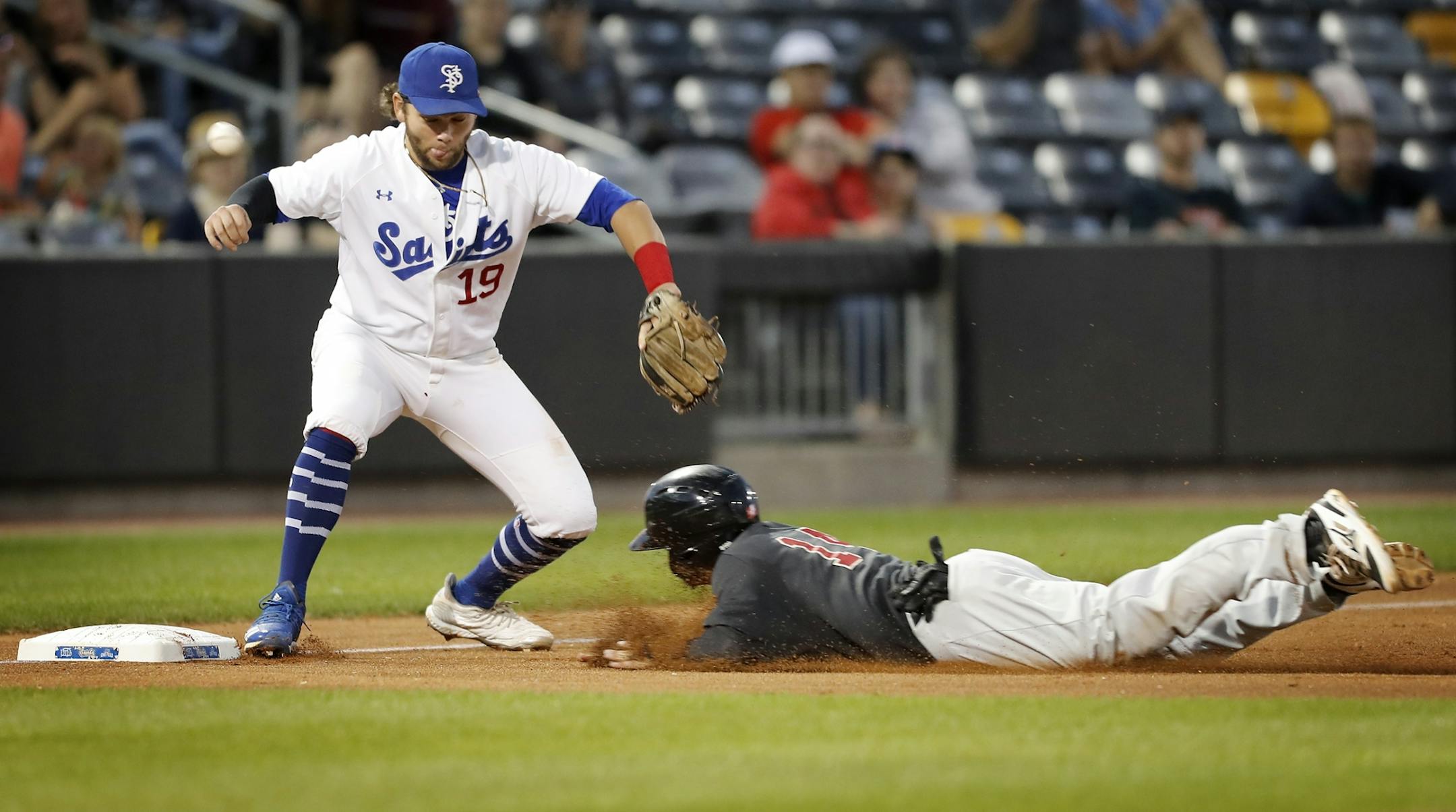 Saint Paul Saints third baseman Dante Bichette Jr. loses the ball and Kansas City's Anthony Phillips is safe at third base.